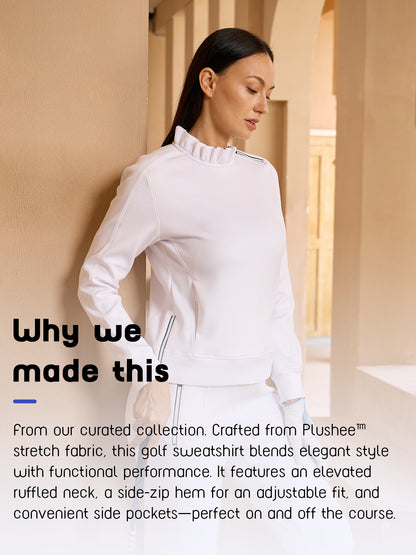 Woman wearing a white ruffled neck performance golf sweatshirt.