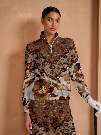 Woman wearing a floral print quarter-zip golf pullover and matching patterned golf trousers.