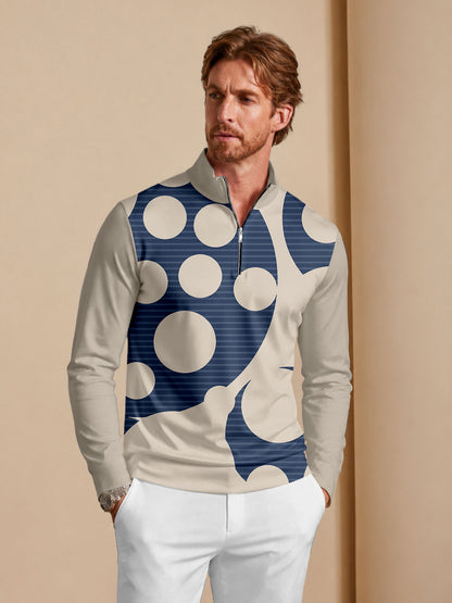 Man wearing a quarter-zip golf pullover with a navy and beige abstract circle pattern.