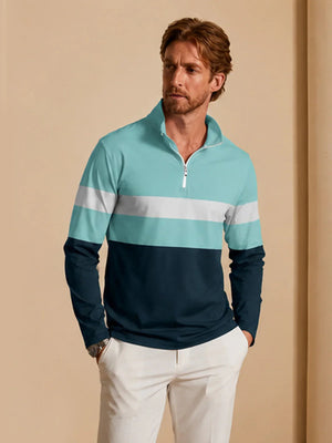 Man wearing a light blue and navy long sleeve quarter-zip performance golf pullover.