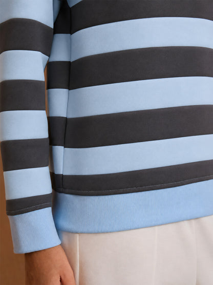 Women's light blue and navy striped long sleeve golf pullover with ribbed hem.