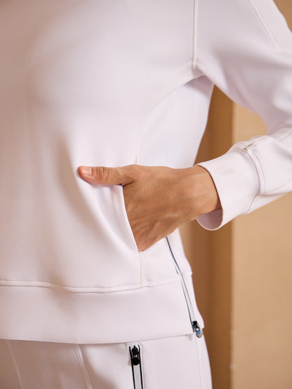 Woman wearing a white performance golf jacket with a side pocket.