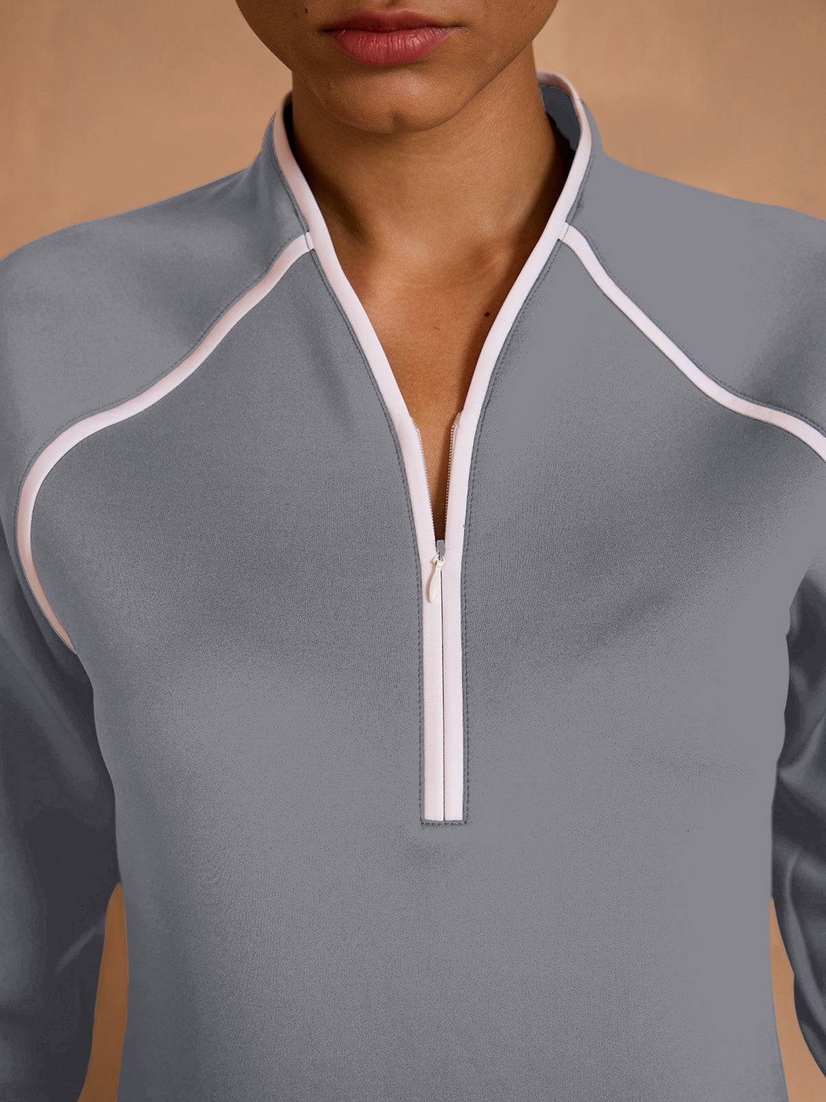 Women's grey performance golf pullover with white trim and quarter zip closure.