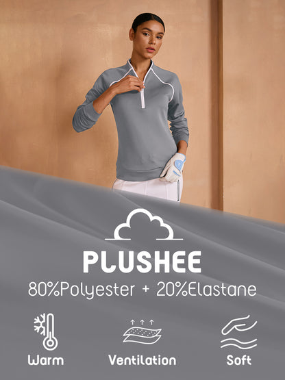 Woman wearing a grey long-sleeve performance golf pullover and white skirt.