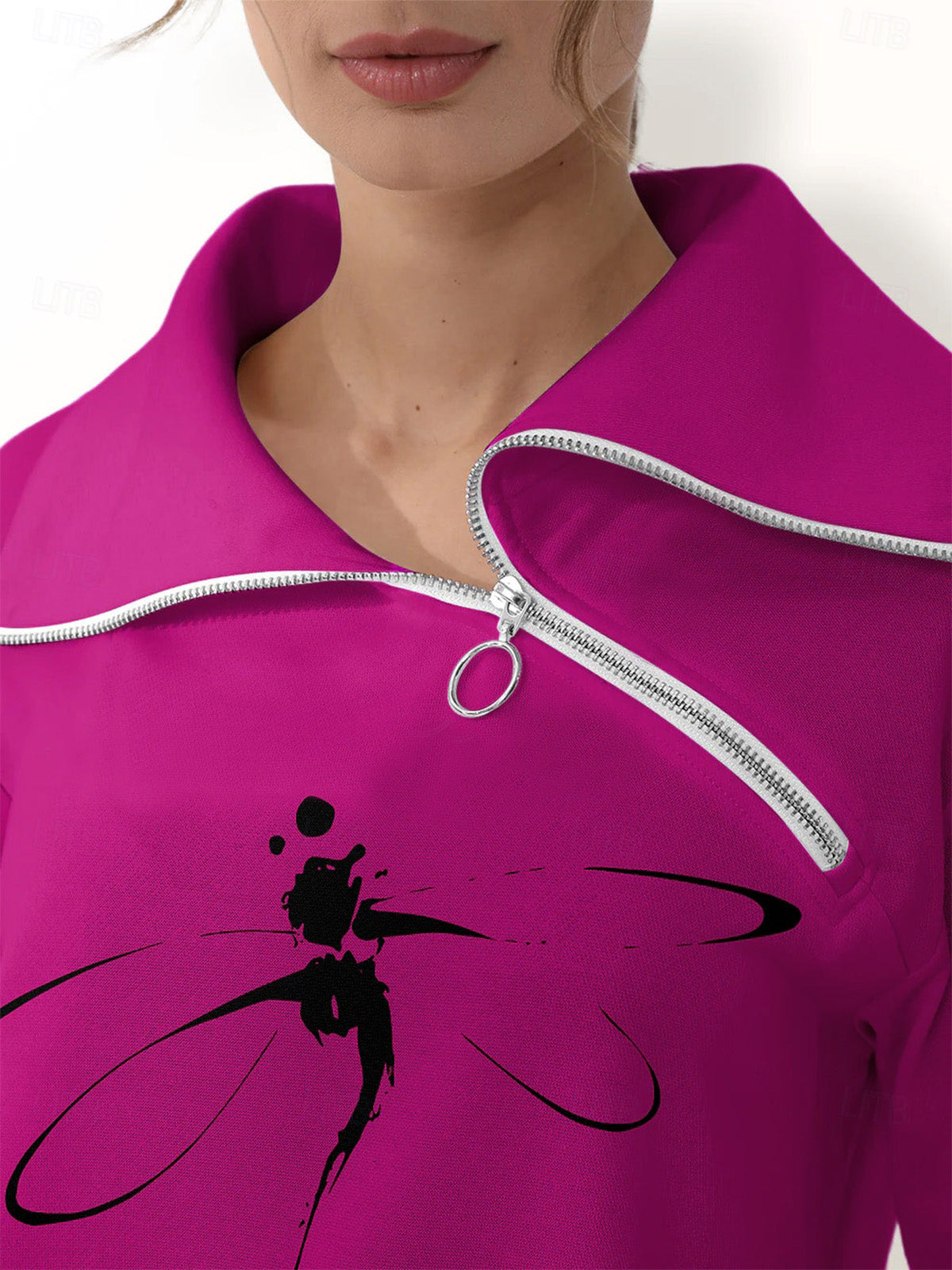 Close-up of a magenta women's golf pullover with a silver quarter-zip and black dragonfly print.