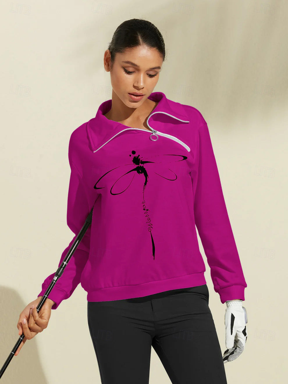 Woman wearing a magenta quarter-zip golf pullover with a black dragonfly graphic.