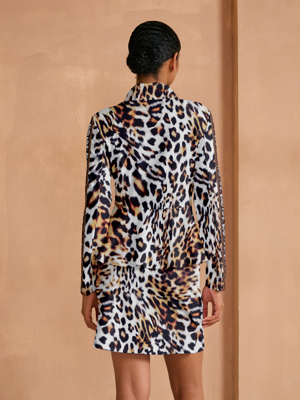 Woman wearing a leopard print long sleeve top and matching mini skirt set.
