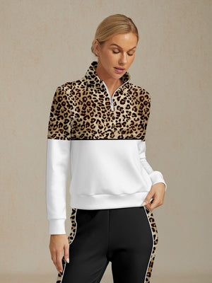 Woman wearing a leopard print quarter-zip golf pullover and black performance golf pants.