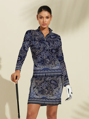 Woman in blue paisley print long sleeve golf polo and matching golf skirt.