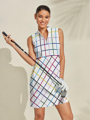 Woman wearing a colorful plaid sleeveless women's golf dress holding a golf club.