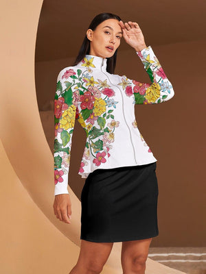 Woman wearing a white long-sleeve golf jacket with floral print and a black golf skirt.