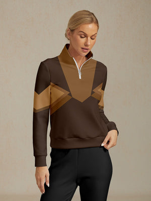 Woman wearing a brown and tan geometric patterned quarter-zip golf pullover.