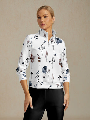 Woman wearing a white quarter-zip golf pullover with a blue and brown floral print.