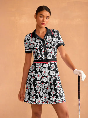 Woman wearing a black and white floral print women's golf dress holding a golf club