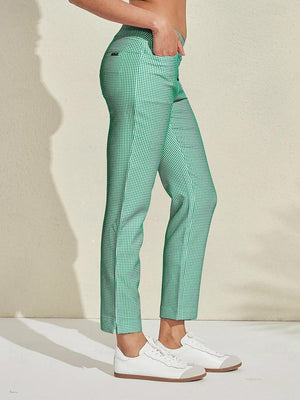 Woman wearing green and white gingham patterned women's golf trousers and white sneakers.